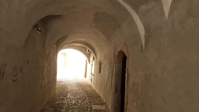 going through old town medieval tunnel in slovenia small village skofja loka scenic cobblestone alley europe european travel dark light