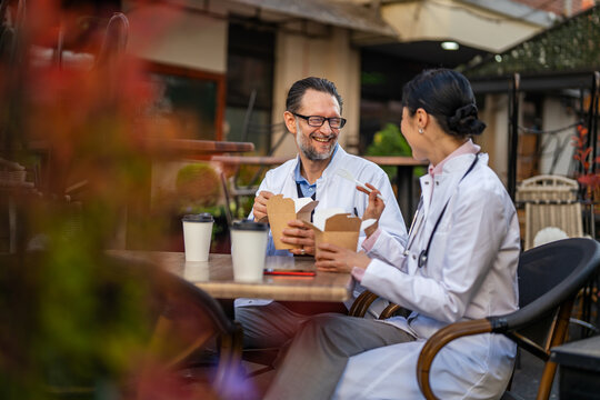 Doctors enjoying lunch break together at outdoor cafe