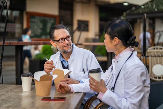 Doctors taking lunch break outdoors discussing work