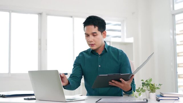 Confident young businessman auditing revenue report and planning budget while working at desk in office.