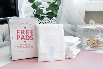 Free menstrual pads box with feminine hygiene products on table