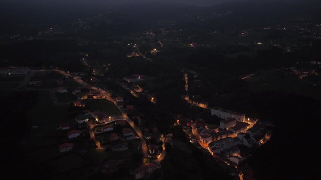 Aerial view of the illuminated streets and traditional houses of the coastal village at night in Cudillero, Asturias, Spain.