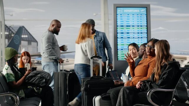 Chatting, metal benches and multiracial travel buddies sitting in busy airport lounge. Waiting for airplane arrival, conversations and group of friends sitting on chair seats