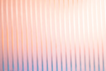 Fototapeta premium Soft peach and pink gradient light on vertical ribbed glass texture