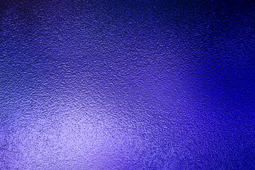 Dark blue textured background with a bright illuminated spot in the corner © Jess rodriguez