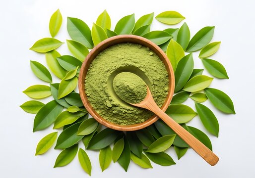 Green tea powder in a wooden bowl with spoon and leaves