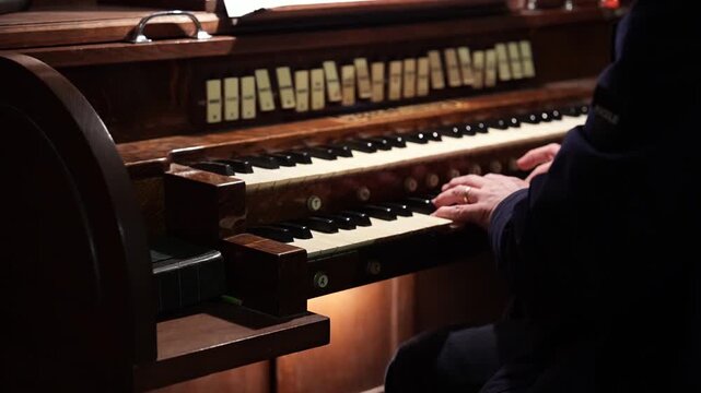 Vintage organ musician performing classical music on traditional wooden keyboard instrument
