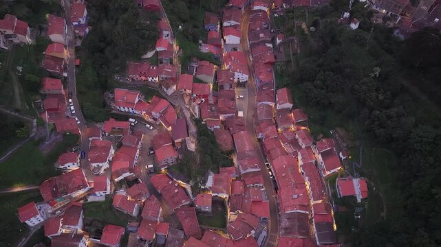 Aerial view of the colorful houses and red rooftops of the historic village at dusk in Cudillero, Asturias, Spain.