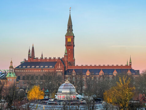 Copenhagen, Denmark - December 31, 2025: City hall under Christmas winter sunset light against ligh blue sky. Tivoli Gardens in front