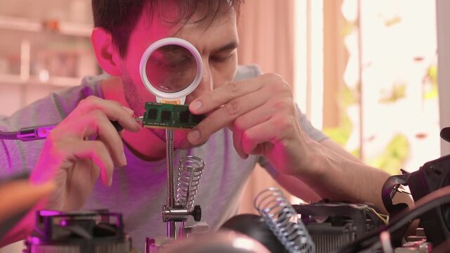 Scientist analyzes prototype circuit in creative workspace atmosphere. Innovator carefully tests experimental electronic device amidst vibrant studio setting with tools