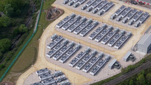 Aerial view of Ferrybridge Battery Energy Storage Systems with rows of white storage units on a gravel site in Knottingley, England, United Kingdom.