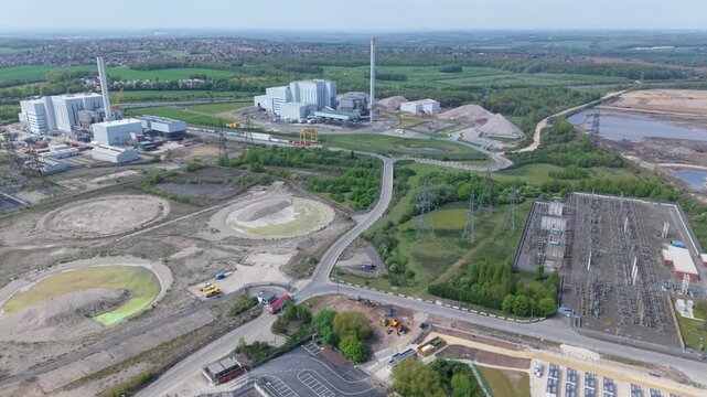 Aerial view of Enfinium 1 and 2 Ferrybridge waste-to-energy plant with its tall chimneys and power substation surrounded by green fields Knottingley, England, United Kingdom.