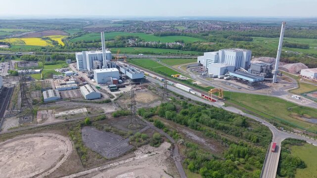 Aerial view of Enfinium 1 and 2 Ferrybridge waste-to-energy plant with tall chimneys and industrial buildings surrounded by green fields in Knottingley, England, United Kingdom.