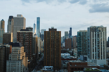 Obraz premium View of Chicago skyline with tall buildings and a cloudy sky during late afternoon