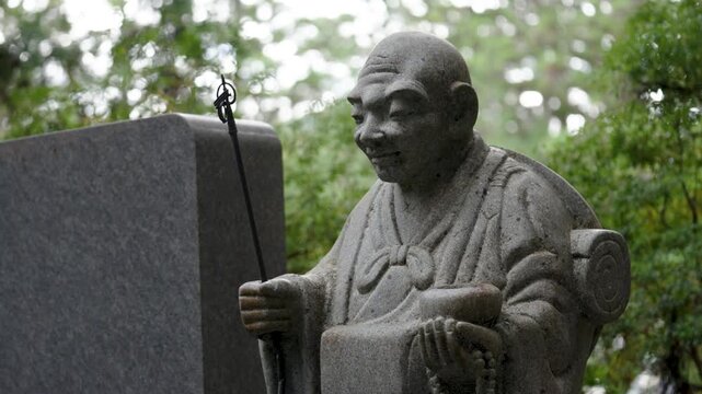 Stone Jizo Bosatsu Statue Wearing Red Bib in a Japanese Temple Garden