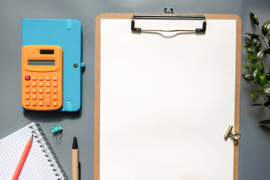 White paper with calculator and pencil on wood background,Office Desk Business concept.