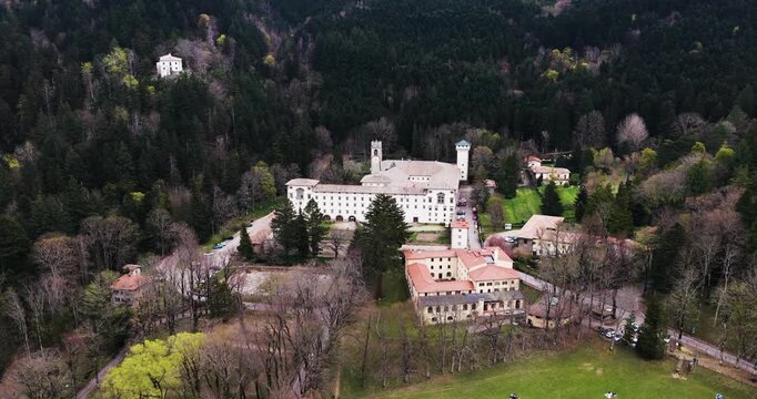 Aerial view of Vallombrosa Abbey with its historic white facade and towers nestled in the lush green forests of the Apennine Mountains, Vallombrosa, Tuscany, Italy.