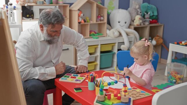 Man handing a wooden block and colorful bead toy to little girl at a play table in a childcare building, visible hand to hand passing of toy; calm bonding moment.