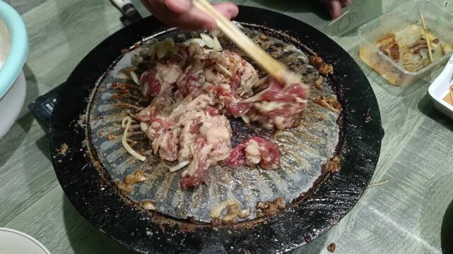 Sizzling Beef and Onions Cooking on a Korean BBQ Grill