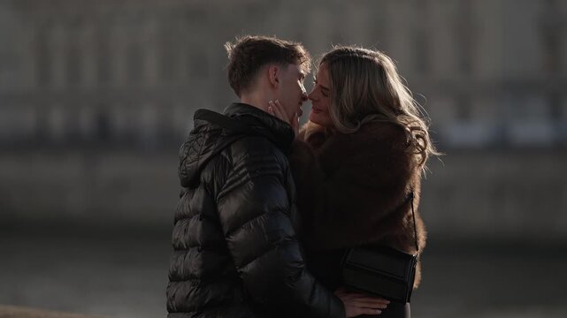 A young couple embraces in a romantic moment in Paris France The man and woman share an intimate connection with soft lighting and a blurred background conveying affection and tenderness.