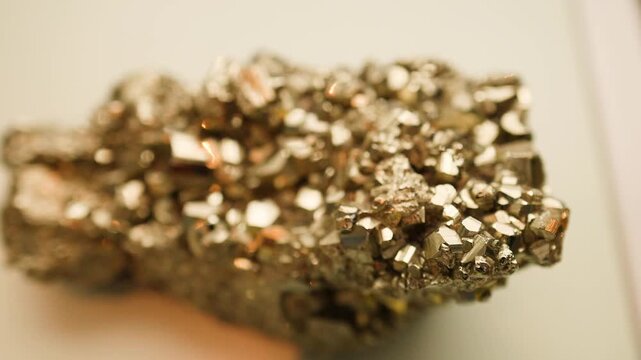 Close up shot of pyrite mineral rock shimmering with light in a laboratory.