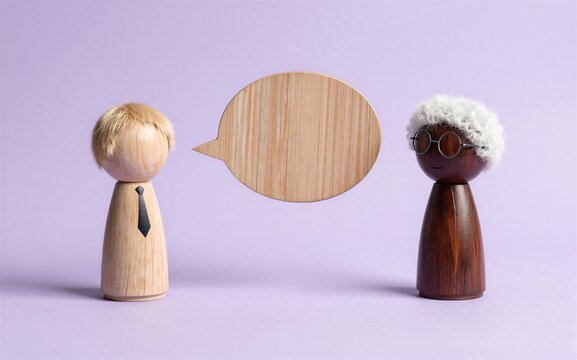 Two wooden figures converse one with a speech bubble between them.