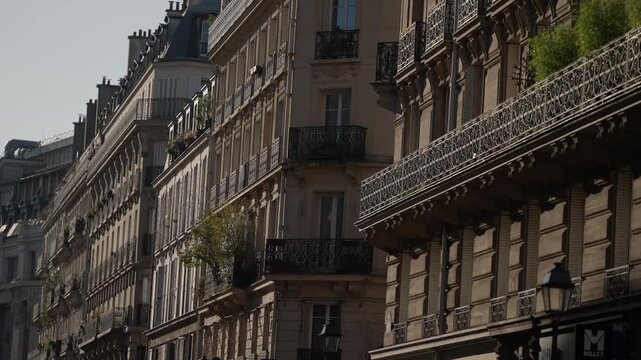 Establishing shot of a classic Parisian street with traditional architecture and wrought-iron balconies The buildings are bathed in sunlight creating a warm and inviting scene. Perfect for travel life