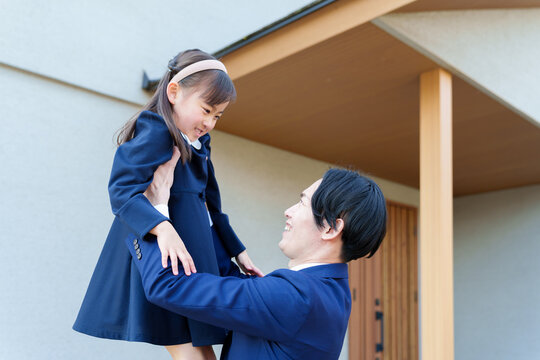 自宅の前で女の子を持ち上げるお父さん