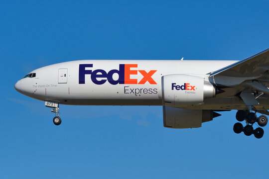 FedEx Express Boeing 777F (N873FD) cargo aircraft on final approach with landing gear deployed.