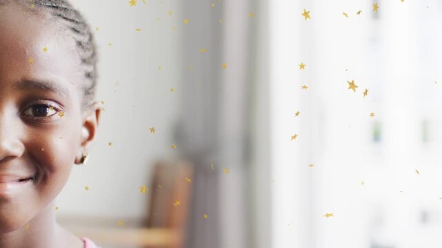Girl smiling in close portrait, gold star overlay playing across lens adding playful education mood