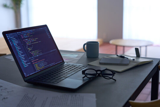Programming code displayed on laptop screen on dark desk