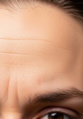 Fototapeta premium Macro view of skin texture focusing on faint forehead creases gradually deepening into permanent furrows as a visual metaphor for aging, time, maturing, sequence