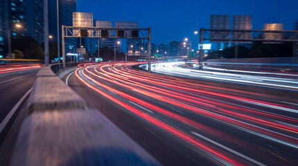 Dynamic long exposure photograph of car light trails on a busy city highway at dusk. © Michelle