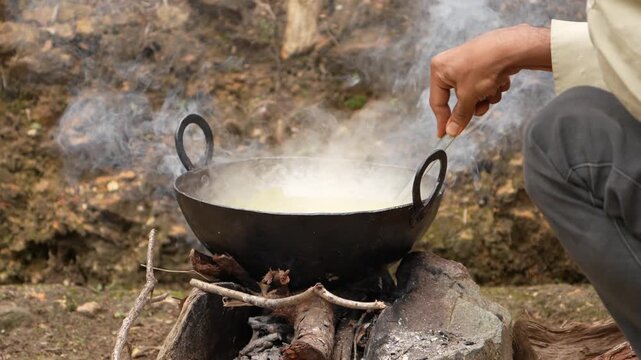 Traditional Outdoor Cooking in Iron Wok over Wood Fire