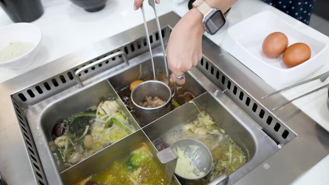 Cooking Raw Pork in a Boiling Hot Pot at a Restaurant