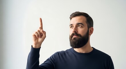 Fototapeta premium Thoughtful Bearded Man Pointing Up Against Minimal Light Background