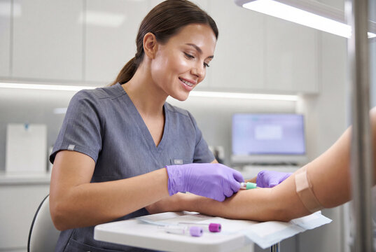 Professional phlebotomist drawing a blood sample from a patient arm