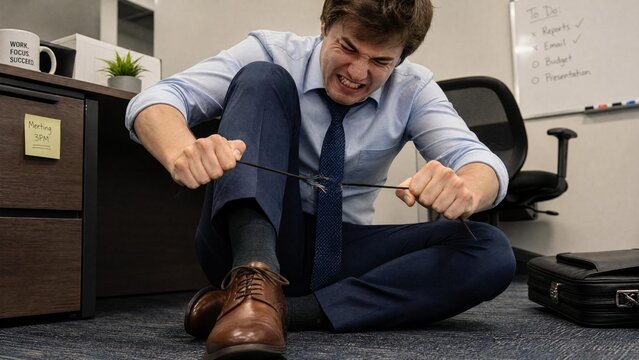 Frustrated Stressed Businessman Pulling and Breaking Cable on Office Floor