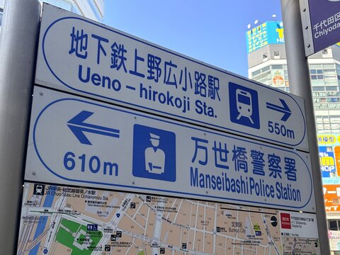 Street signage at Kotani Building showing directions to Manseibashi Police Station and Ueno-Hirokoji Subway Station in Chiyoda district - Tokyo, Japan, February 21, 2026