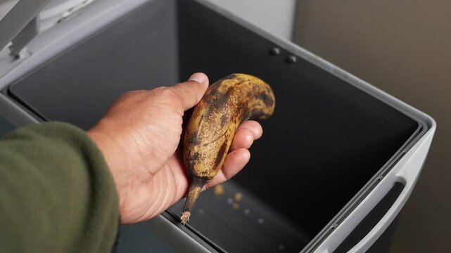Banana is placed in a trash bin for disposal