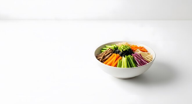 Fresh bibimbap bowl with colorful sliced vegetables and green onion garnish