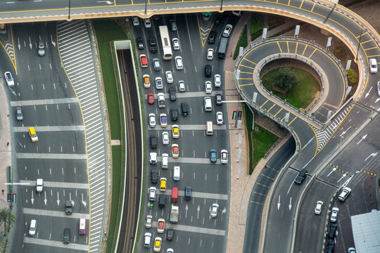 View of heavy traffic flow on a multi-lane highway with cars and buses near a circular overpass ramp in Dubai, Dubai, United Arab Emirates.