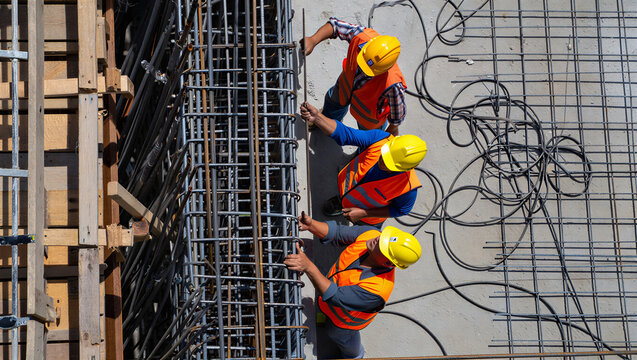 Top view of construction workers installing rebar reinforcement for a concrete slab