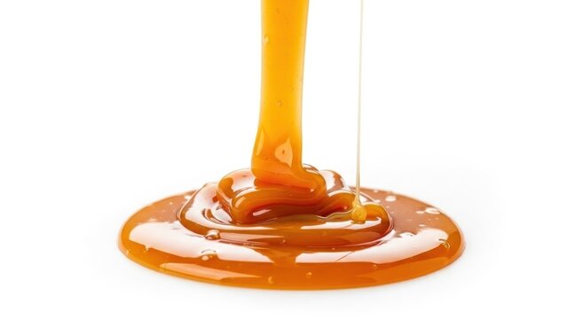 A stream of golden syrup pouring and pooling on a flat surface