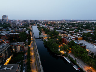 Fototapeta premium Montreal skyline and Lachine Canal at blue hour with illuminated cityscape and urban waterfront, Canada. g.