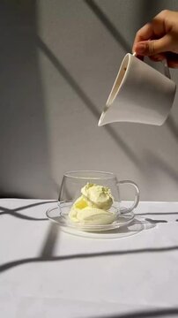 Making Affogato Dessert by Adding Ice Cream Into Clear Glass and Pouring Black Coffee