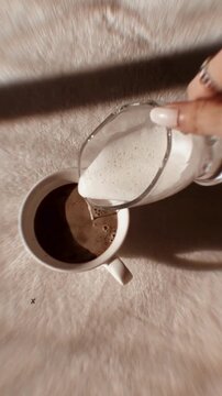 Slow Motion Pouring Creamer Into Hot Coffee Cup with Cozy Aesthetic Atmosphere