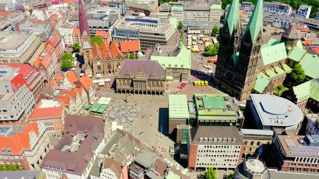 Bremen, Germany. St. Petri Dom twin spires and Bremen Town Hall on the Marktplatz, Drone footage over red rooftops and historic Hanseatic architecture under clear summer sky.. Drone footage, Point of