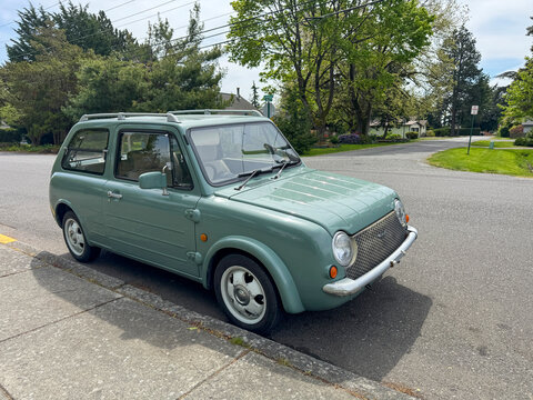 Vintage 1989 mint green Nissan Pao retro hatchback parked on a suburban Street. Bellingham, WA, USA - 30 April 2026