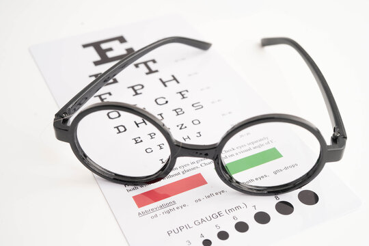Glasses on eye testing exam chart to check eyesight accuracy of reading.
